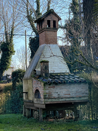 <div>Prekäres Artefakt auf Rädern, das <em>gerade in den Boden eingelassen wird</em>.</div>